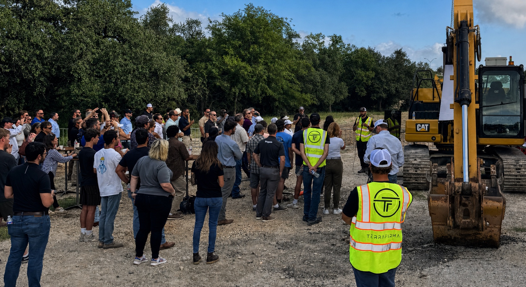 People gathered beside excavators during an equipment briefing